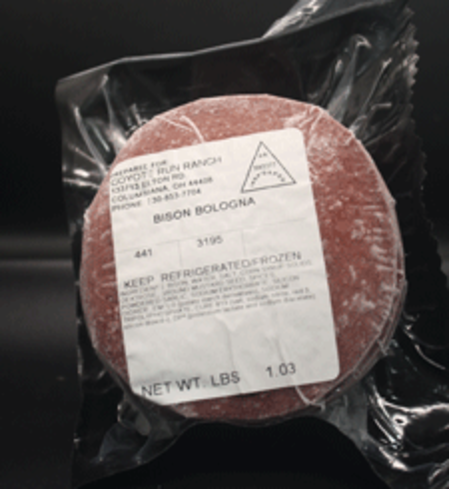 Bison bologna package from Coyote Run Ranch, featuring a label with storage instructions and weight information, placed against a dark background.